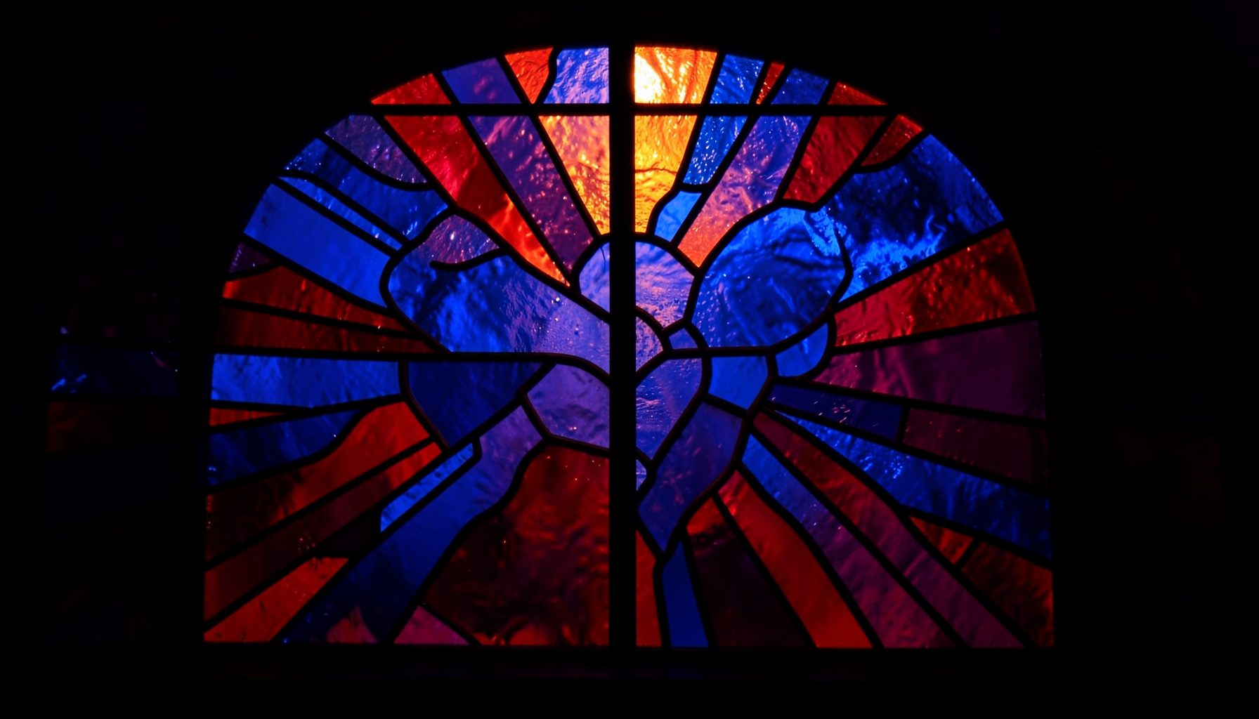 A stained-glass window with bold black lead lines forming a map of interconnected regions, deep navy blue and ruby red glass segments radiating outward, warm amber light shining through.
